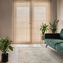 Load image into Gallery viewer, Living room with green sofa, plants, and wooden blinds