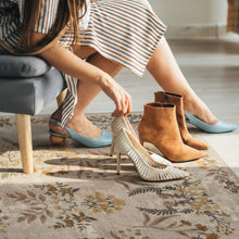 Load image into Gallery viewer, Person trying on high-heeled shoes in a home setting