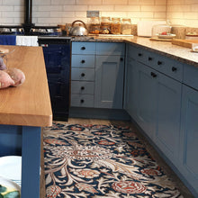 Load image into Gallery viewer, Kitchen with blue cabinets, wooden table, and patterned rug.