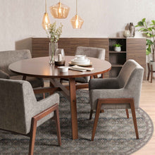 Load image into Gallery viewer, Dining room with a round wooden table and gray chairs, featuring a vase with flowers and plates on the table placed on a round rug.