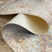 Load image into Gallery viewer, Patterned rug being rolled out on a wooden floor