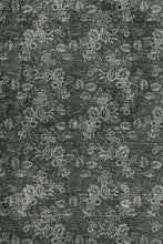Load image into Gallery viewer, A close-up of a dark charcoal gray fabric or material with a distressed, textured surface and an all-over muted floral pattern in lighter gray and off-white tones.