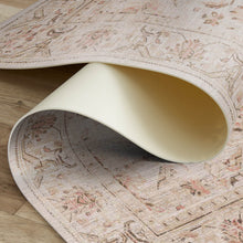 Load image into Gallery viewer, Close-up of a patterned rug with a rolled-up section on a wooden floor.
