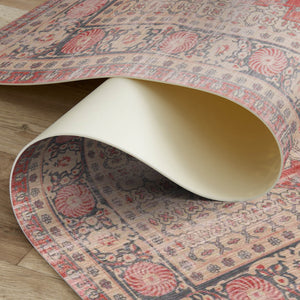 Roll of patterned rug material on a wooden floor