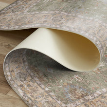 Load image into Gallery viewer, Close-up of a patterned rug with a white chair leg partially visible
