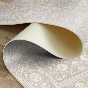 Close-up of a beige patterned rug on a wooden floor