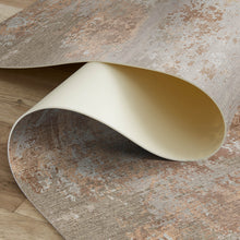 Load image into Gallery viewer, Roll of textured vinyl rug with a beige core on a wooden floor.
