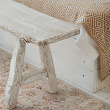 Load image into Gallery viewer, Wooden bench with a textured surface and patterned fabric draped over it on a floral-patterned rug.
