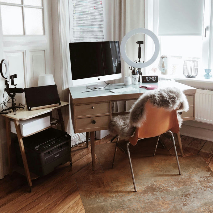 Home office setup with desk, computer, and chair in a bright room.