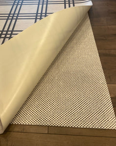 Roll of beige rubber matting on a wooden floor