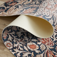 Load image into Gallery viewer, Roll of patterned vinyl mat with intricate designs on a wooden floor.
