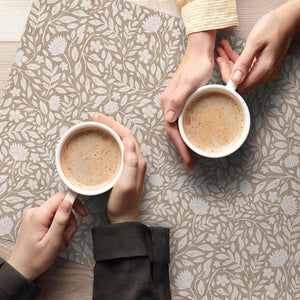 Cup of coffee on hear resistant placemat brown floral pattern