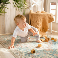 Child playing with wooden blocks on a patterned rug in a home setting