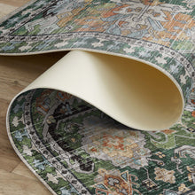 Load image into Gallery viewer, Close-up of a patterned rug being rolled out on a wooden floor.
