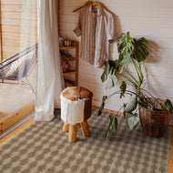 Room interior with a wooden stool, plant, and hanging shirt.