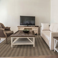 Living room with beige sofa, wooden coffee table, and TV on a stand.