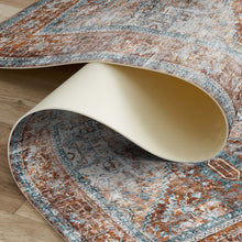 Load image into Gallery viewer, Patterned rug being rolled out on a wooden floor
