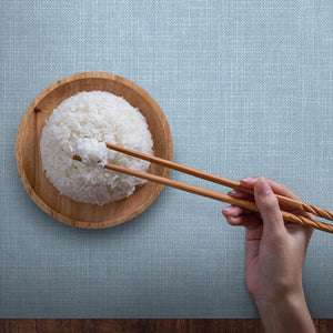 bowl or rice served on a beautiful light blue placemat